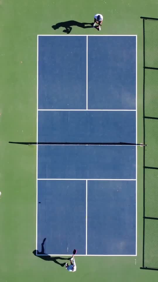 Two people playing pickleball outdoors